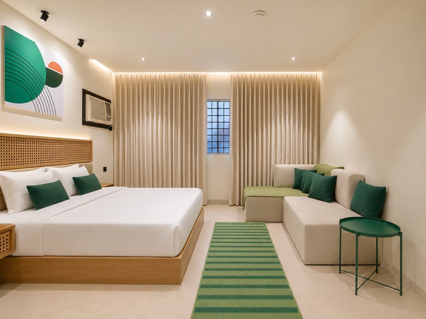 A bedroom with a lounge corner and green accents — Ibn Khaldun